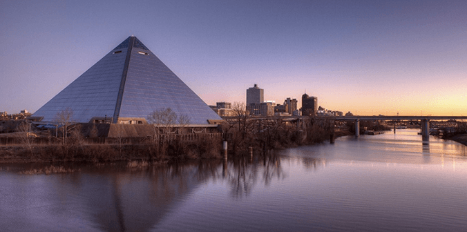 Memphis, TN pyramid on the Mississippi river with bridge in background at sunset
